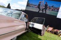 Spectators watch the movie Grease at an open air cinema as motoring enthusiasts attend the Goodwood Revival, a three-day classic car racing festival celebrating the mid-twentieth century heyday of the sport, at Goodwood in southern Britain, September 7, 2