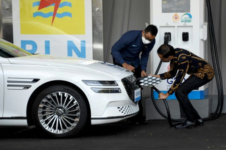 Indonesia's President Joko Widodo (right) helps charge an electric car at the launch of the first public electric vehicle charging station in Nusa Dua, Bali in March 2022 ahead of a Group of 20 summit