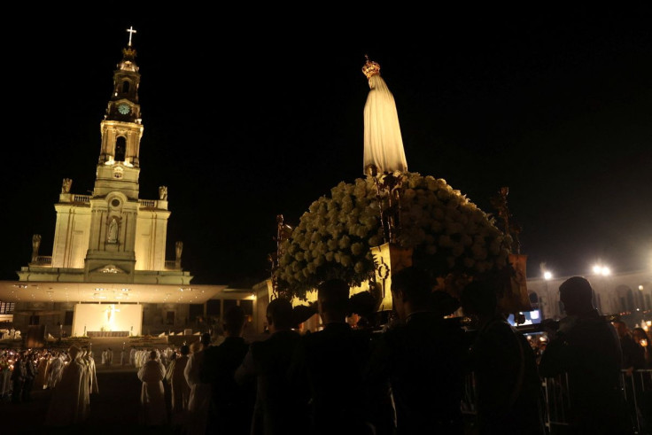 People carry the statue of Our Lady of Fatima (the Virgin Mary) during an event marking the 105th anniversary of the reported appearance of the Virgin Mary to three shepherd children, at the Catholic shrine of Fatima, Portugal, May 12, 2022. Picture taken