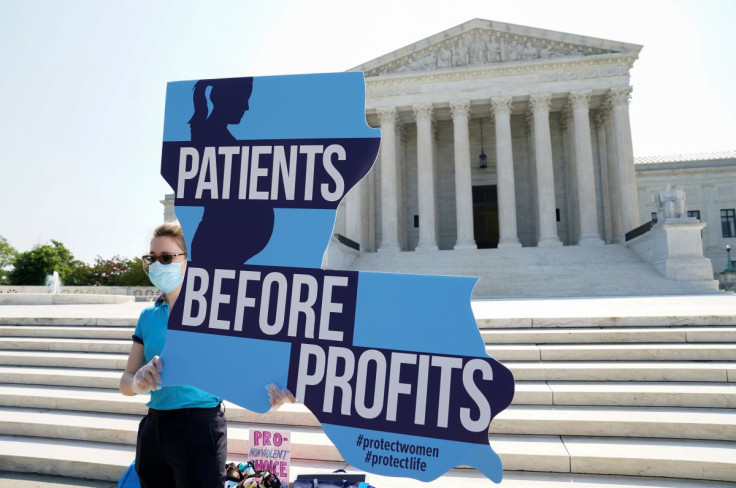 A pro-life demonstrator holds a sign in front of the U.S. Supreme Court as she awaits its decision on the legality of a Republican-backed Louisiana law that imposes restrictions on abortion doctors in Washington, U.S., June 22, 2020. 