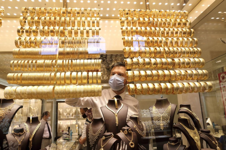 A goldsmith wearing a protective face mask arranges golden bangles as the other talks to customers at a jewellery shop at the Grand Bazaar in Istanbul, Turkey, August 6, 2020. 