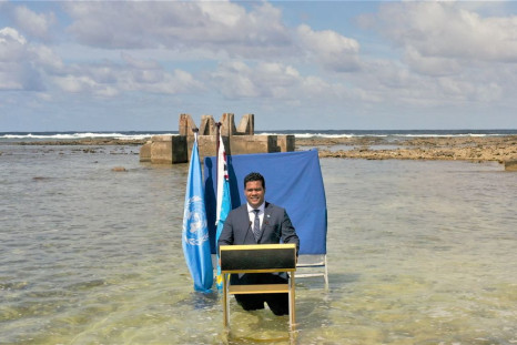 Tuvalu's Foreign Minister Simon Kofe gives a COP26 statement while standing in the ocean in this handout picture taken in Funafuti, Tuvalu, November 8, 2021. Picture taken November 8, 2021. Ministry of Justice, Communication and Foreign Affairs Tuvalu Gov
