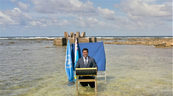 Tuvalu's Foreign Minister Simon Kofe gives a COP26 statement while standing in the ocean in this handout picture taken in Funafuti, Tuvalu, November 8, 2021. Picture taken November 8, 2021. Ministry of Justice, Communication and Foreign Affairs Tuvalu Gov