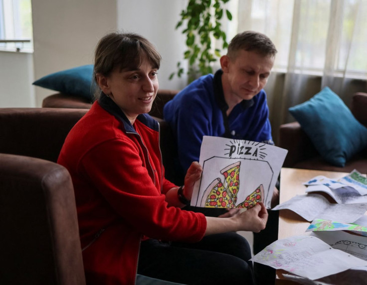 Nataliya and Volodymyr Babeush, who were evacuated from Azovstal plant in Mariupol show children's drawings during an interview with Reuters, amid Russia's invasion in Ukraine, in Zaporizhzhia, Ukraine May 9, 2022.