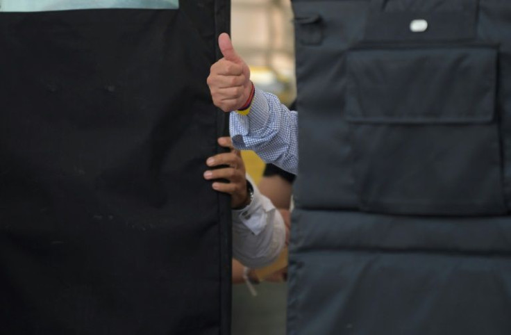 Left-wing Colombian presidential candidate Gustavo Petro waves at supporters from behind bullet proof shields during a campaign rally in May 2022