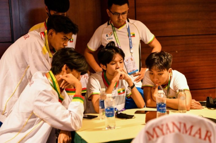 Myanmar eSport members watch a game on a phone at the SEA Games