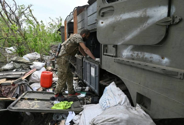 A Ukrainian serviceman inspects a destroyed Russian military vehicle near the village of Mala Rogan east of Kharkiv, on May 13, 2022, amid Russian invasion of Ukraine.