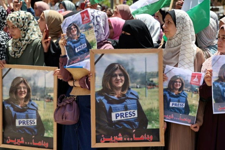 Palestinians hold the portrait of the slain Al Jazeera journalist in Gaza City