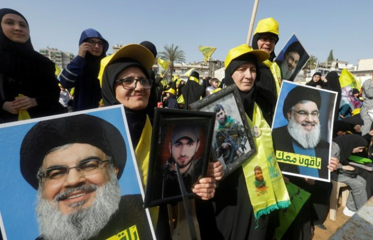 Supporters brandish photographs of Hezbollah leader Hassan Nasrallah at a campaign rally