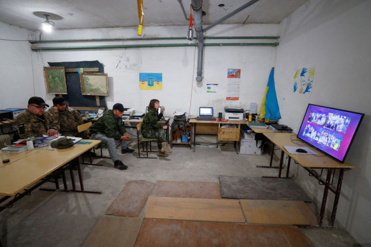 Ukrainian service members wait for the last voting results during the final of the 2022 Eurovision Song Contest, amid Russia's attack on Ukraine, at their position in Kyiv region, Ukraine May 15, 2022. 