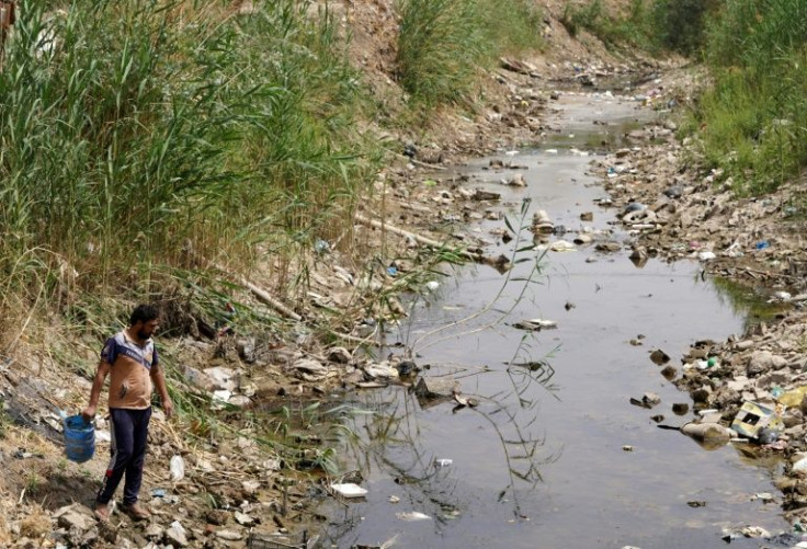 A farmer fetches water from a drying and polluted stream in Najaf province -- Iraq is classified as one of five most vulnerable to climate change effects