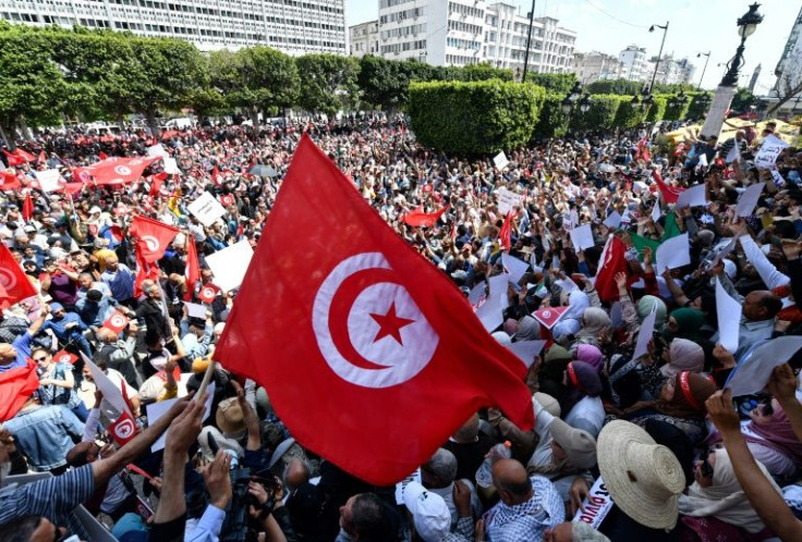 Tunisian protesters wave flags and placards as they demonstrate against President Kais Saied in the capital Tunis