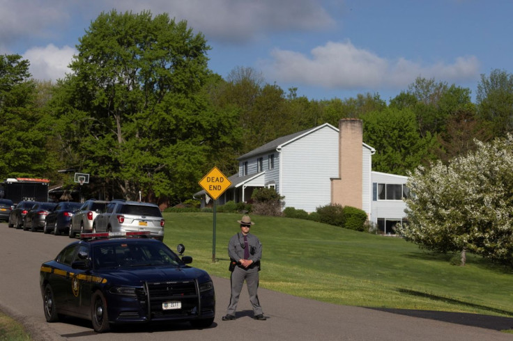 A law enforcement personnel stands outside the home of Buffalo supermarket shooting suspect Payton Gendron in Conklin, New York, U.S. May 15, 2022.  