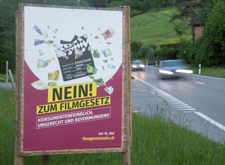 A poster reading: "No to the film law - anti-consumer, unfair, patronising" is seen on a field, before the Swiss electorate votes on several issues in a referendum next weekend, near Birmensdorf, Switzerland May 9, 2022. Picture taken May 9, 2022. 