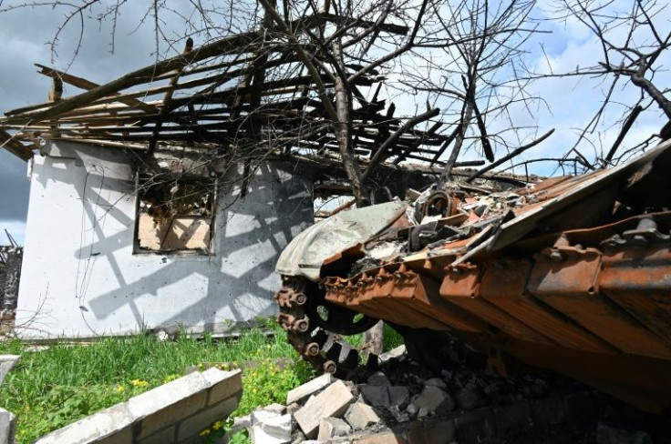 A wrecked Russian tank lies next to a destroyed house in the village of Mala Rogan, east of Kharkiv, Ukraine