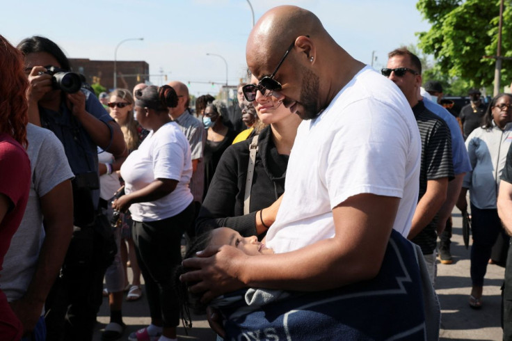 A mourner looks at his child, while attending a vigil for victims of the shooting at a TOPS supermarket in Buffalo, New York, U.S. May 15, 2022. 