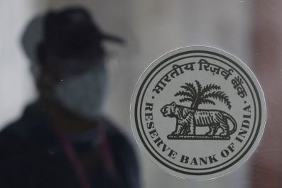 A man walks behind the Reserve Bank of India (RBI) logo inside its headquarters in Mumbai, India, April 8, 2022. 
