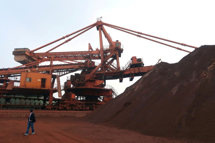 A man walks by an iron ore blending site at Dalian Port, Liaoning province, China September 21, 2018. 