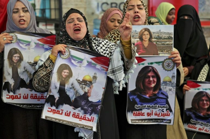 Palestinian women hold pictures of Al Jazeera journalist Shireen Abu Akleh during a demonstration in solidarity with prisoners in Israeli jails, outside the ICRC headquarters in Gaza City on May 16, 2022