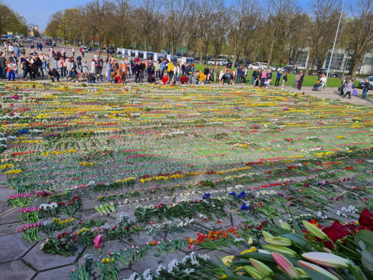 People lay flowers at a monument commemorating the Soviet Union's victory over Nazi Germany in World War Two, in Riga, Latvia, on May 10, 2022.
