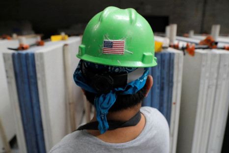 A U.S. flag is seen on the hard hat of a worker in the factory at IceStone, a manufacturer of recycled glass countertops and surfaces, in New York City, New York, U.S., June 3, 2021. 
