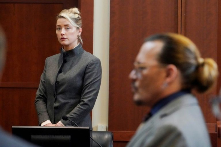 Actors Amber Heard and Johnny Depp watch as the jury leaves the courtroom for a lunch break at the Fairfax County Circuit Courthouse in Fairfax, Virginia
