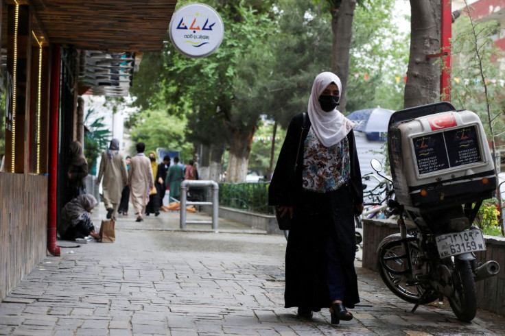 An Afghan woman walks on a street in Kabul, Afghanistan, May 9, 2022. 