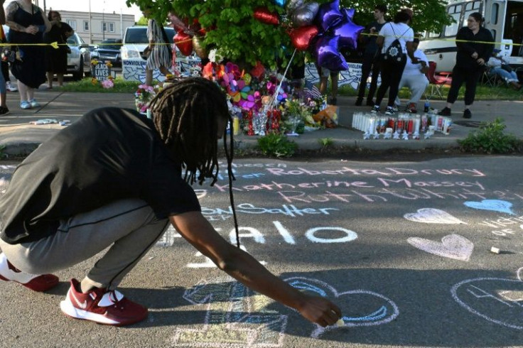 People leave messages at a makeshift memorial near a Tops Grocery store in Buffalo, New York, the day after a gunman shot dead 10 people