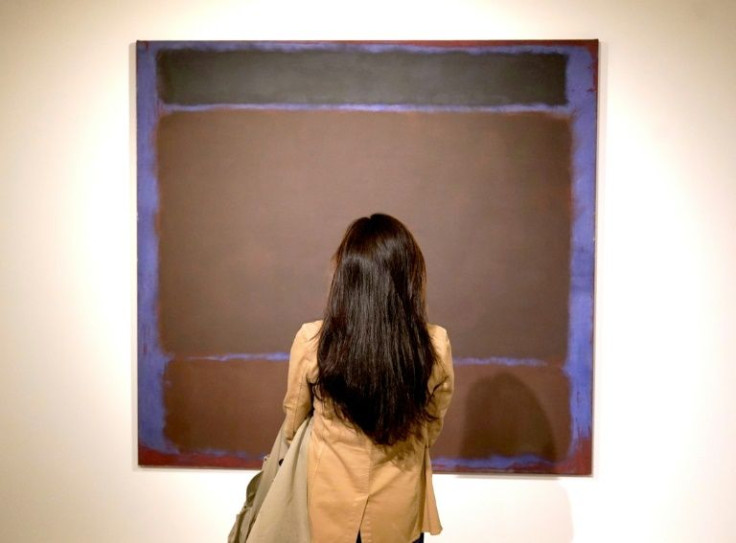 A person poses in front of Mark Rothkoâs âUntitledâ during a press preview on May 6, 2022 for the Macklowe Collection at Sotheby's in New York