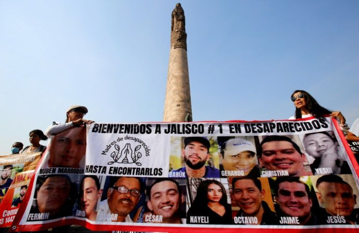 Mexican mothers whose children are missing hold a banner with their pictures during a protest to demand government action on Mother's Day  in the city of Guadalajara