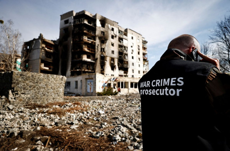War crime prosecutor's team member speaks on the phone next to buildings that were destroyed by Russian shelling, amid Russia's Invasion of Ukraine, in Borodyanka, Kyiv region, Ukraine April 7, 2022. 