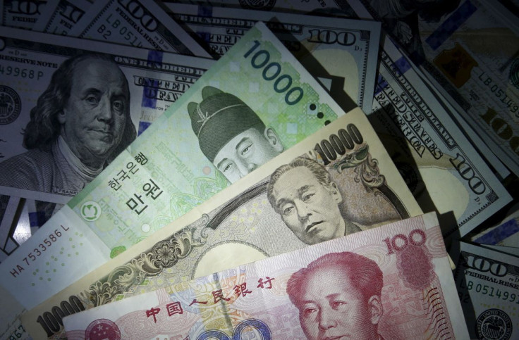 South Korean won, Chinese yuan and Japanese yen notes are seen on U.S. 100 dollar notes in this picture illustration taken in Seoul, South Korea, December 15, 2015.