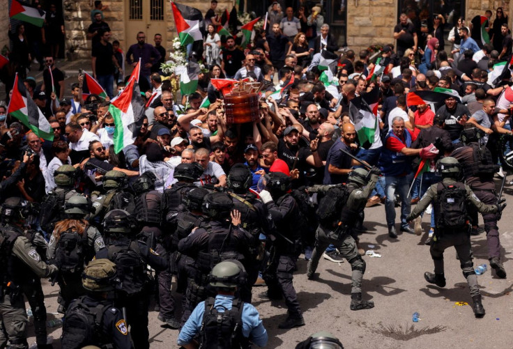 Family and friends carry the coffin of Al Jazeera reporter Shireen Abu Akleh, who was killed during an Israeli raid in Jenin in the occupied West Bank, as clashes erupted with Israeli security forces, during her funeral in Jerusalem, May 13, 2022. 