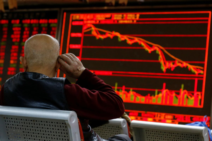 FILE PHOTO - An investor sits in front of a board showing stock information at a brokerage office in Beijing, China, December 7, 2018.  