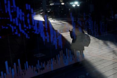 A woman using her mobile phone is reflected on an electric board showing exchange rates of various cryptocurrencies at Bithumb cryptocurrencies exchange in Seoul, South Korea, January 11, 2018.  