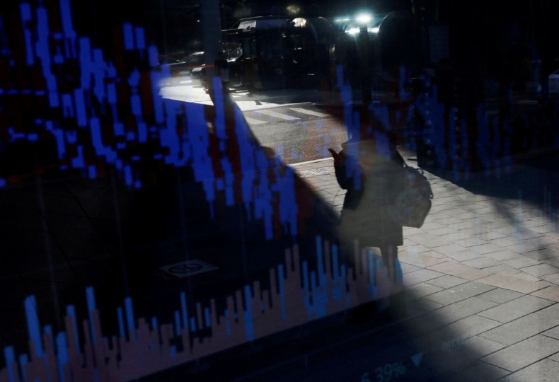 A woman using her mobile phone is reflected on an electric board showing exchange rates of various cryptocurrencies at Bithumb cryptocurrencies exchange in Seoul, South Korea, January 11, 2018.  
