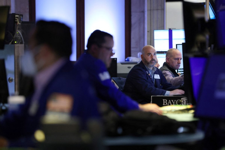 FILE PHOTO - Traders work on the trading floor at the New York Stock Exchange (NYSE) in Manhattan, New York City, U.S., May 18, 2022.