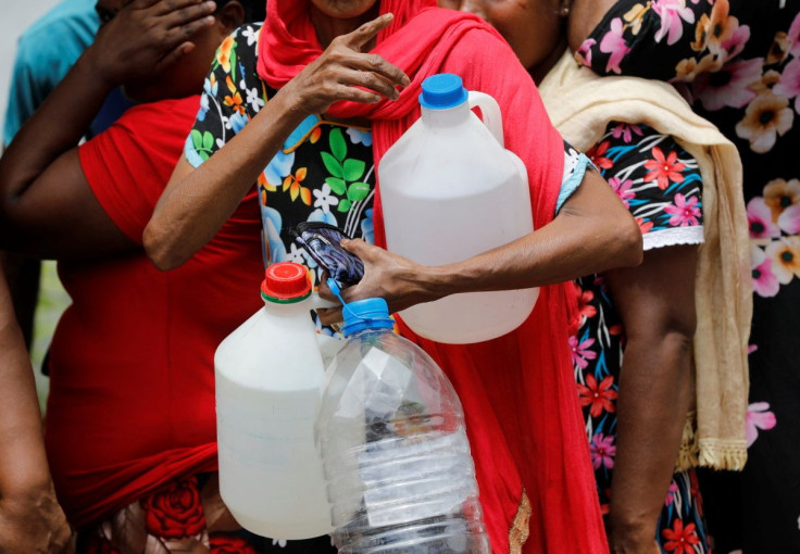 A woman holds empty containers as she waits in a queue to buy kerosene at a fuel station, amid the country's economic crisis in Colombo, Sri Lanka, May 18, 2022.
