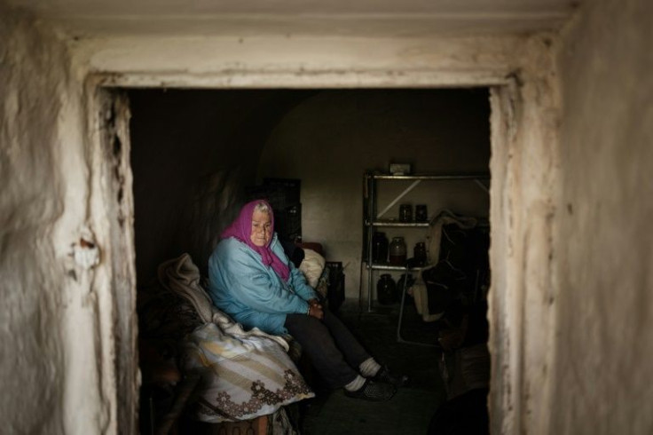 Galina Polyakova, 81, sits on her bed in her vegetable cellar that has been transformed into a shelter in Sydorove, eastern Ukraine