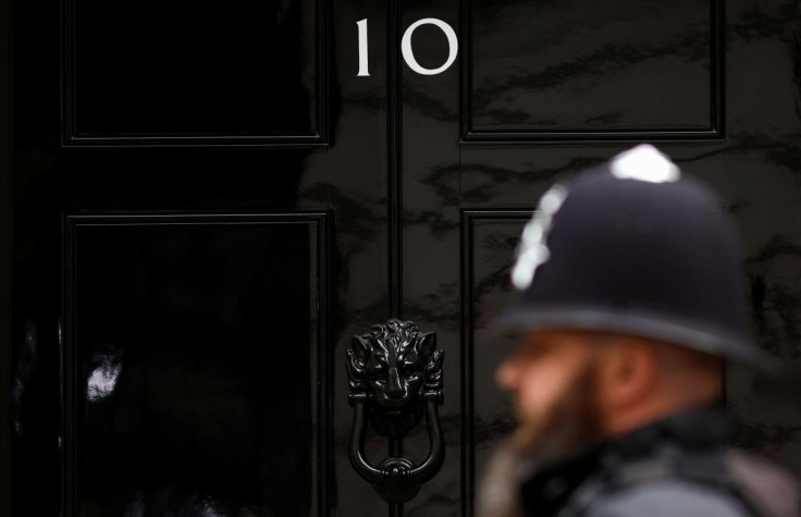 A police officer walks past the door of No. 10 Downing Street in London, Britain, April 13, 2022. 
