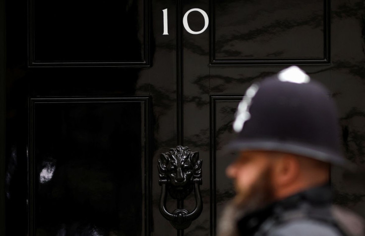 A police officer walks past the door of No. 10 Downing Street in London, Britain, April 13, 2022.