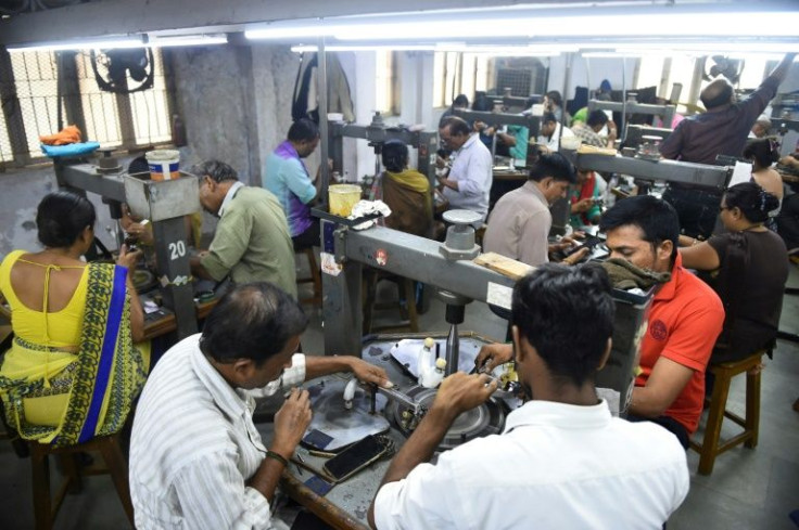 Indian workers examine diamonds at a cutting and polishing workshop in Ahmedabad