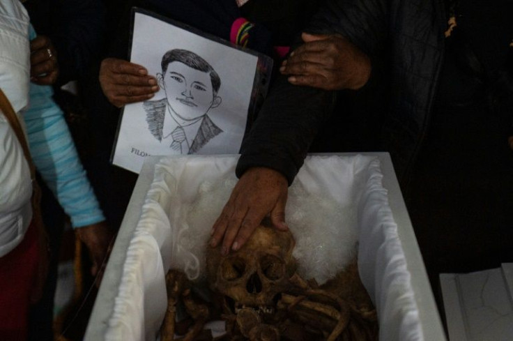 A relative touches the remains of a victim of the Accomarca massacre, carried out in 1985, after the bodies were excavated, identified and given new coffins