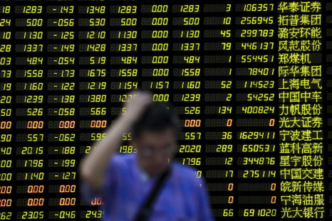FILE PHOTO - An investor stands in front of an electronic board showing stock information at a brokerage house in Shanghai, China, August 24, 2015. 