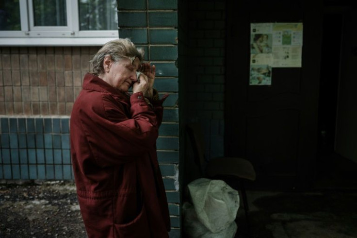 A woman stands at the entrance to a makeshift shelter in a kindergarten basement in Lysychansk