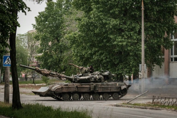 A Ukrainian tank drives on a street during nearby mortar shelling in Severodonetsk, eastern Ukraine