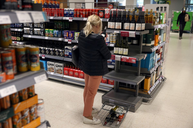 A woman looks at wine bottles displayed on a shelf in a supermarket in London, Britain, May 19, 2022. 