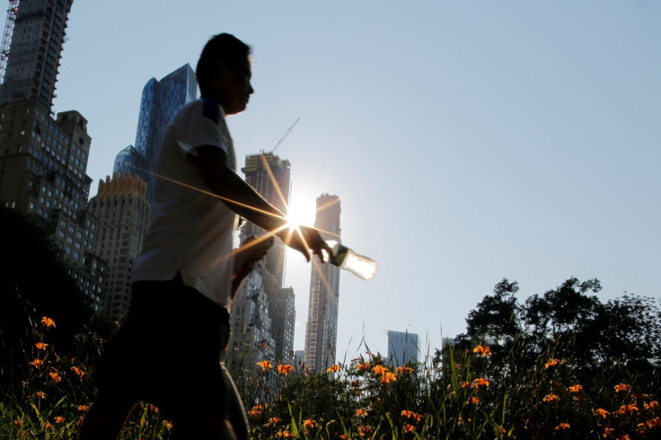 A man carries a bottle of water on a hot summer day in Central Park, Manhattan, New York, U.S., July 1, 2018.  