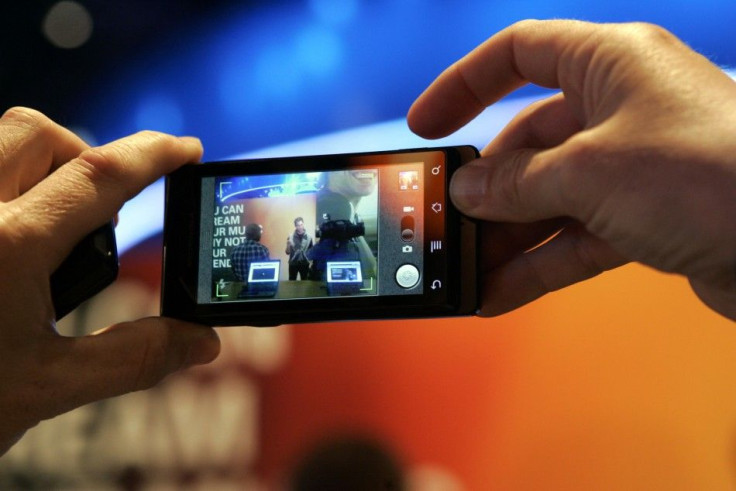 A man takes a photo with a Motorola Milestone smartphone during the 2010 International CES in Las Vegas