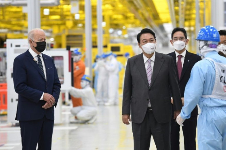 US President Joe Biden (L) stands next to South Korean President Yoon Suk-yeol (2L) during their visit to the Samsung plant